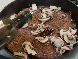 Patties and mushrooms frying