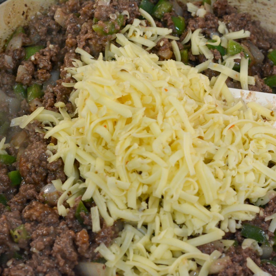 Once the meat mixture is ready, stir in the shredded pepper jack cheese. Cover the skillet and let the cheese melt for a minute or two.