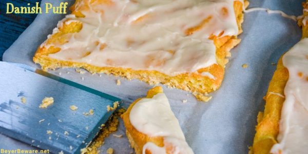 Almond Danish Puff Pastry has a flaky thin crust with a soft eggy bread layer that is drenched in almond flavoring and then covered with a light almond icing.