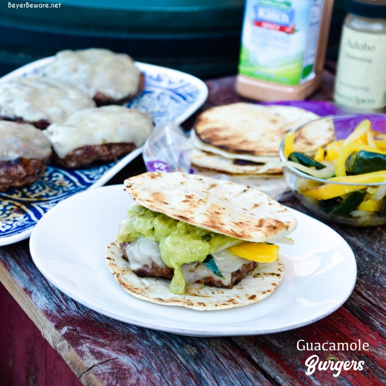 Guacamole burgers combine taco night with burger night straight from the grill with flavorful burgers, pepper-jack cheese, guacamole, sauteed onions, peppers, and street taco tortilla shells.