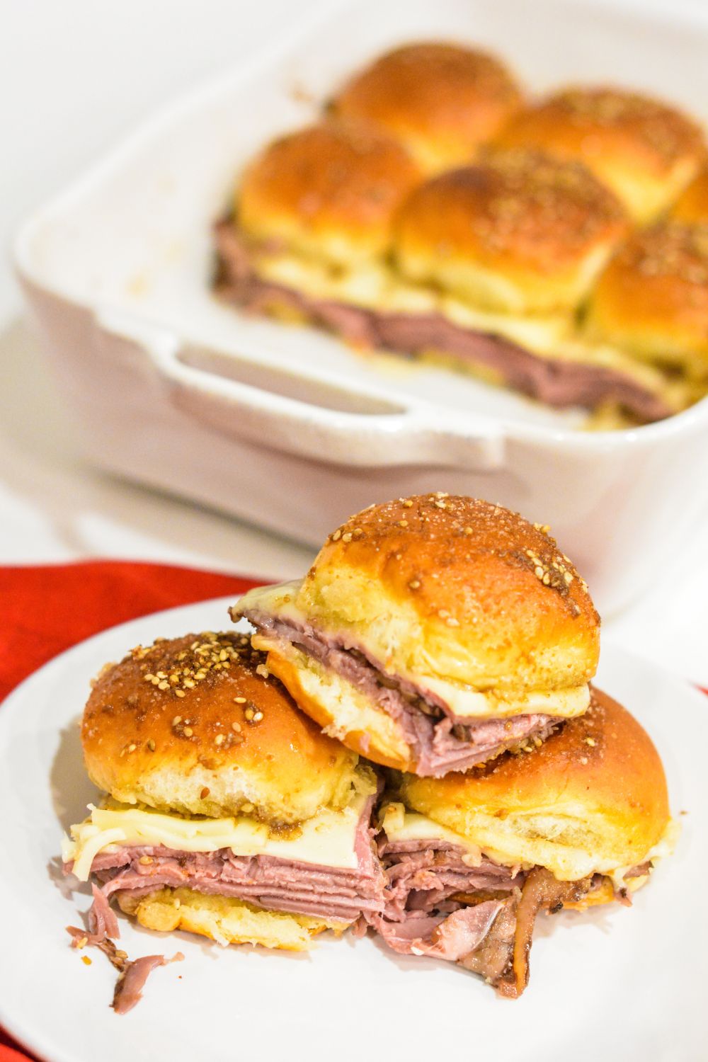 Roast Beef Hawaiian Roll Sliders, also known as Sandy's Sandwiches, combine butter, garlic powder, Worcestershire sauce, and poppy seeds for a butter glaze that complements these baked roast beef and cheese sandwiches. These sandwiches are easy to make in 10 minutes and bake for 20-25 minutes.