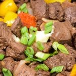 Garlic pepper steak bites recipe is an easy cast iron steak skillet meal made with an easy marinated sirloin steak, garlic, onions, and bell peppers served over mashed potatoes or rice.