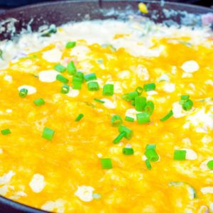 Give the hot corn dip a good stir. Top off with the remaining shredded cheese and smoke until it is melted.