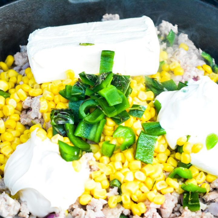 Stir in the corn, cream cheese, mayonnaise, and sour cream. Let smoke until the cream cheese is melted.