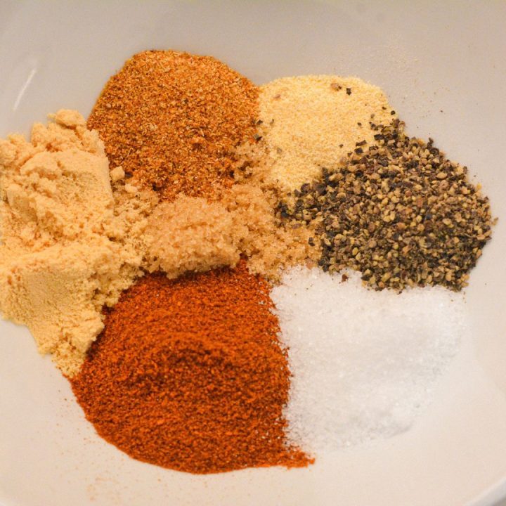 In a small bowl, combine the garlic powder, onion powder, ground mustard, black pepper, brown sugar, kosher salt, and paprika. Mix well until all the ingredients are evenly distributed. This dry rub will give your pork chops a perfect blend of sweet, savory, and spicy flavors.