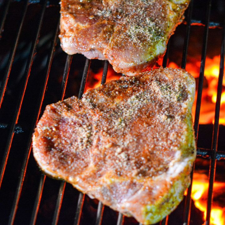 Brush the grill grates with a bit of olive oil to prevent sticking. Place the pork chops on the grill and cook for about 4-5 minutes per side or until the internal temperature reaches 145°F