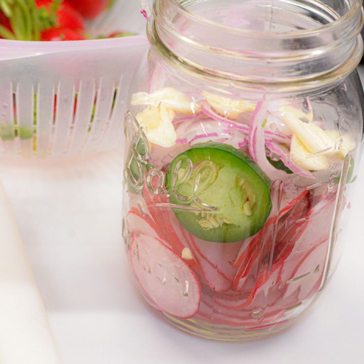 Pack the jars by layering the sliced radishes, onions, and jalapenos. Top off with the sliced garlic.