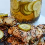 Pickle brined grilled chicken is made by marinating boneless, skinless chicken thighs in pickle juice, pickles, onions, garlic, peppercorns, and olive oil resulting in the juiciest grilled chicken.