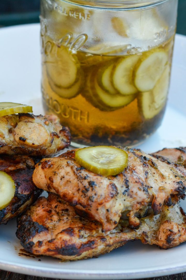 Pickle brined grilled chicken is made by marinating boneless, skinless chicken thighs in pickle juice, pickles, onions, garlic, peppercorns, and olive oil resulting in the juiciest grilled chicken.