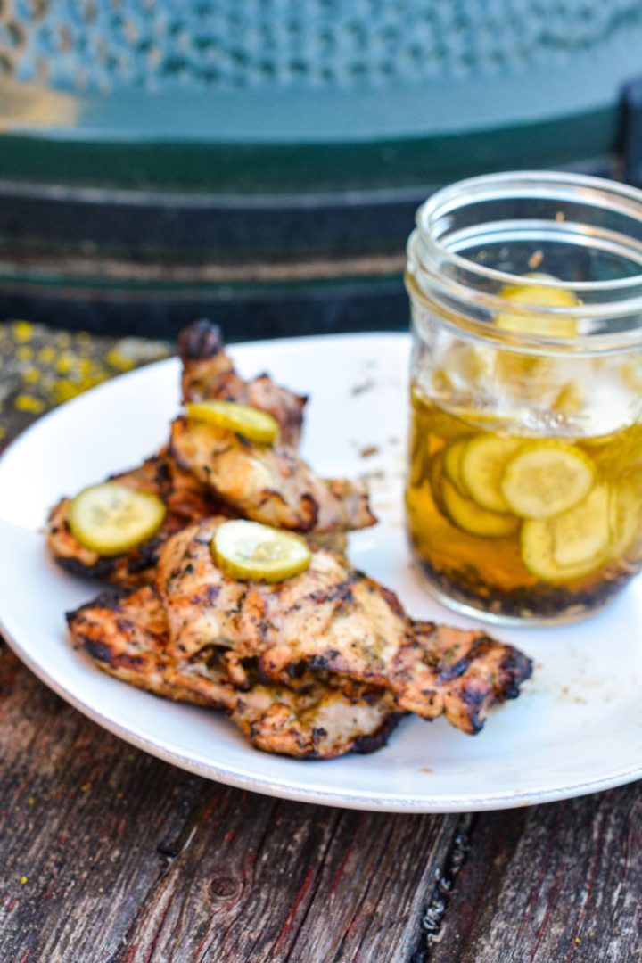 Pickle brined grilled chicken is made by marinating boneless, skinless chicken thighs in pickle juice, pickles, onions, garlic, peppercorns, and olive oil resulting in the juiciest grilled chicken.