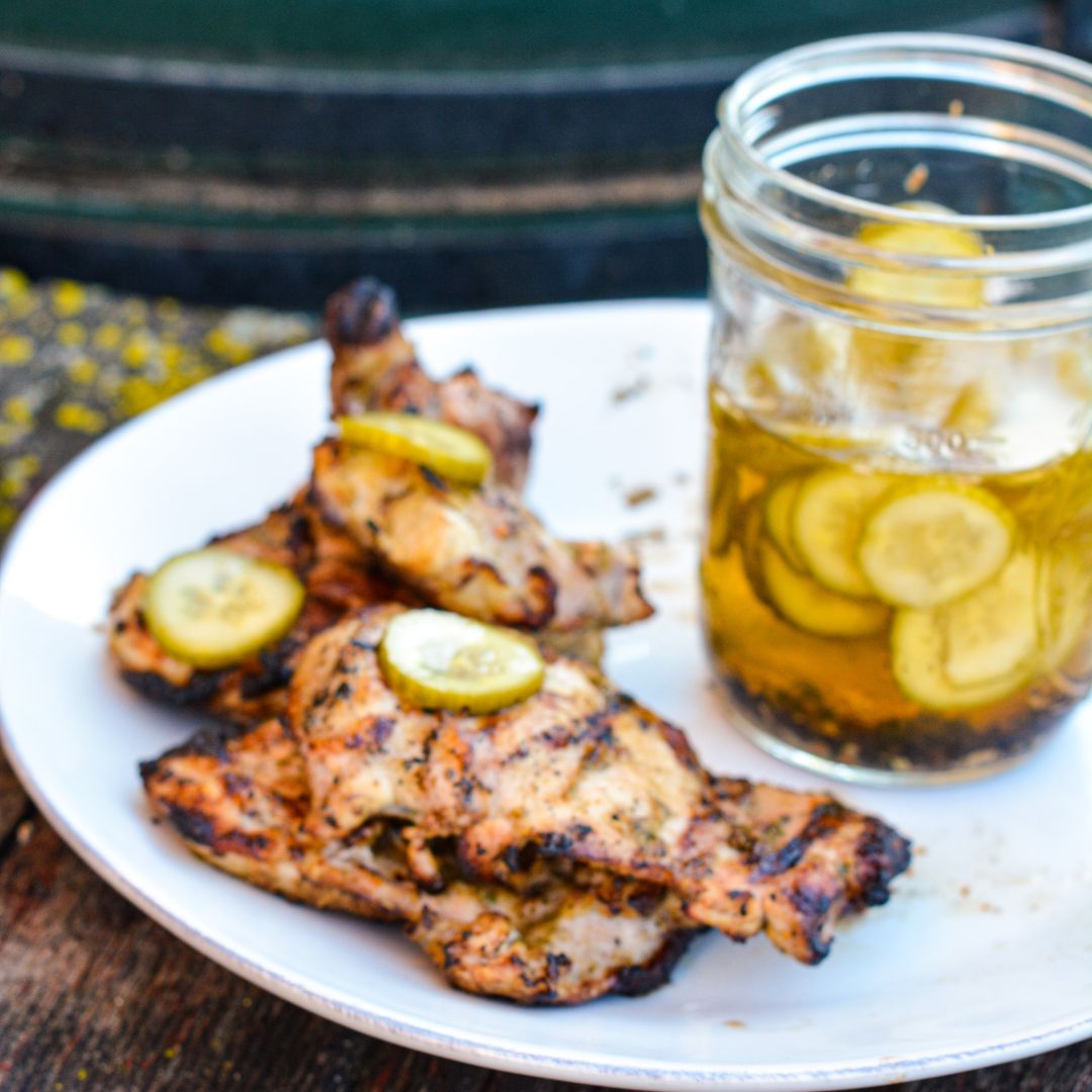 Pickle brined grilled chicken is made by marinating boneless, skinless chicken thighs in pickle juice, pickles, onions, garlic, peppercorns, and olive oil resulting in the juiciest grilled chicken.