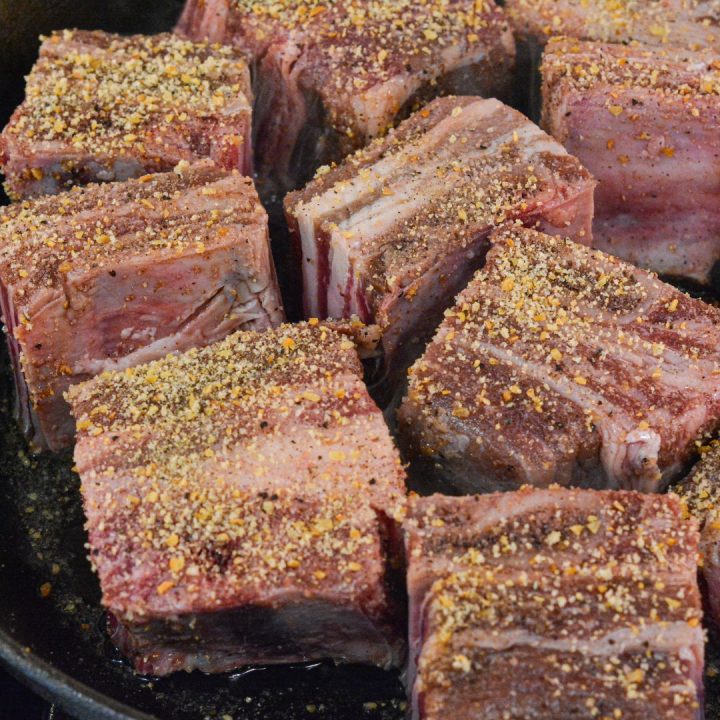 Generously season the short ribs with the garlic salt and pepper on all sides. In a large skillet, heat the canola oil over medium-high heat. Once hot, sear the short ribs on all sides until browned.