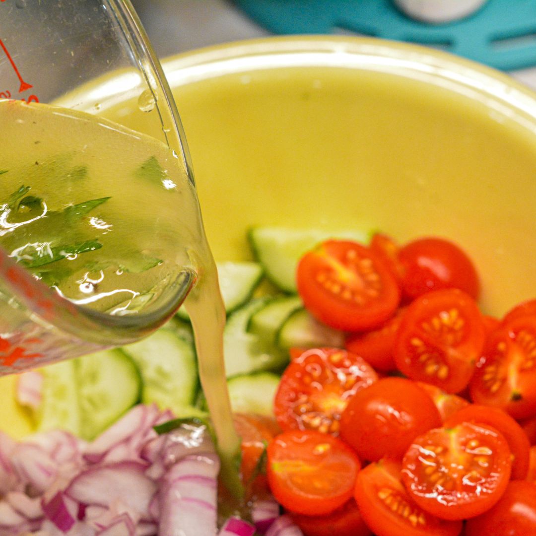 Pour the dressing over the tomato, cucumber, and onion salad. Stir to combine and let it set in the refrigerator for 30 minutes before serving.