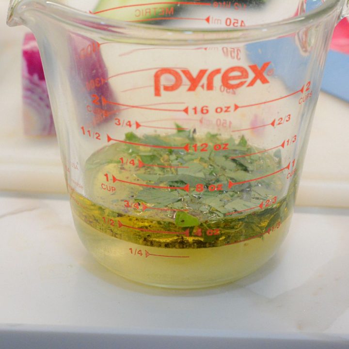 Next, mix the white wine vinegar, olive oil, sugar, salt and pepper in a small bowl or measuring cup. Sprinkle the chopped parsley, basil, and mint (if using) into the dressing. Mix to dissolve the sugar and salt. If you like, you can also add 