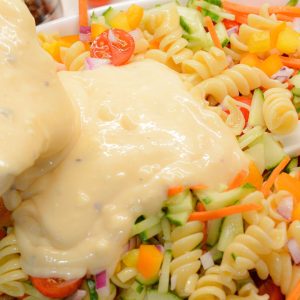 Finally, pour the dressing over the vegetables and pasta. Gently toss everything together until the pasta and vegetables are well coated with the creamy dressing.