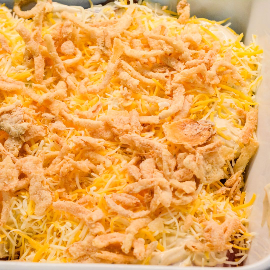 Sprinkle the shredded Colby Jack cheese over the pork chops, creating a thick, cheesy layer. Finally, top off with the French fried onions.