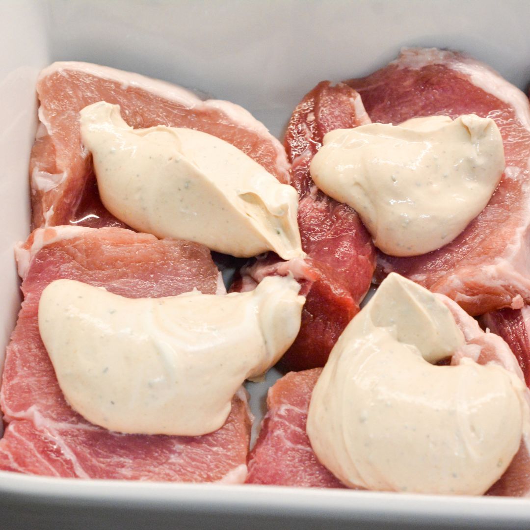 Spread the creamy ranch mixture evenly over the top of each pork chop, ensuring they are fully covered. This will keep the pork chops moist and flavorful as they bake.