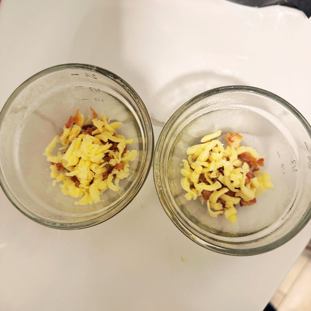 Spray a small microwave-safe bowl and add bacon and shredded cheese to the bottom.