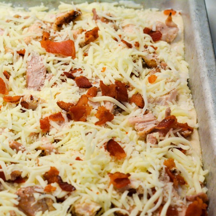 Cover the pizza with shredded mozzarella and parmesan cheese. Spread the toppings evenly so every bite is cheesy and delicious.