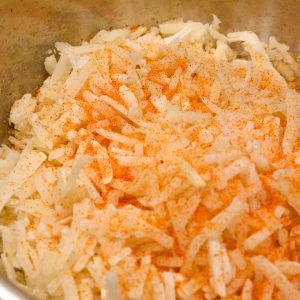 Start by thawing the frozen hash browns. Add the seasoning salt to the shredded potatoes or hash browns.