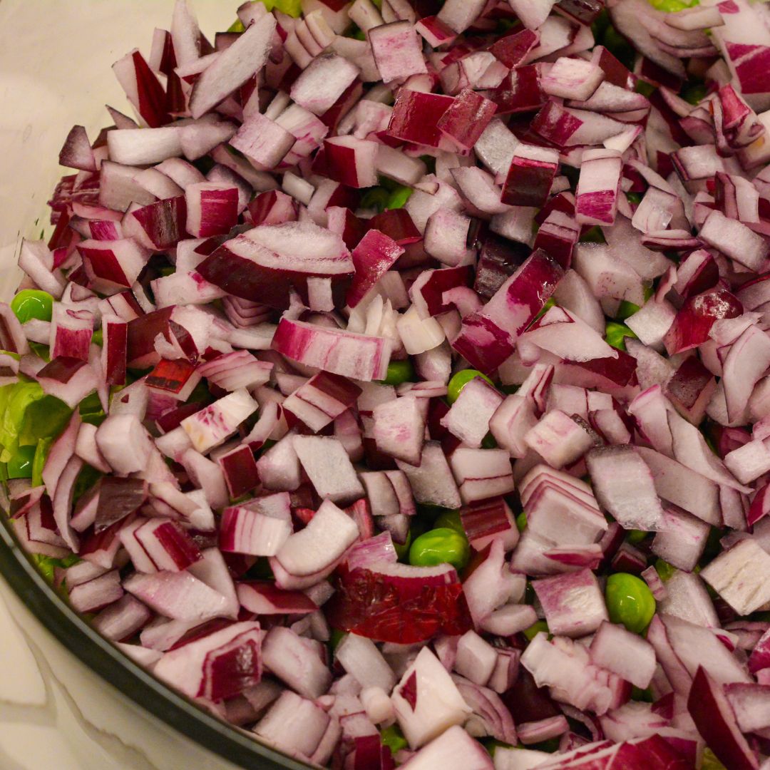 Add the red onions and peas to the top of the lettuce.