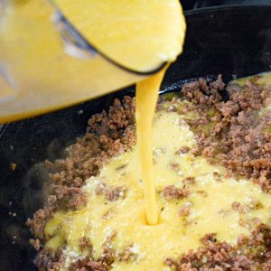 Brown the Sausage -In a large skillet, brown the sausage over medium heat, breaking it into crumbles as it cooks. Once browned, pour the egg mixture over the sausage and cook until halfway cooked.